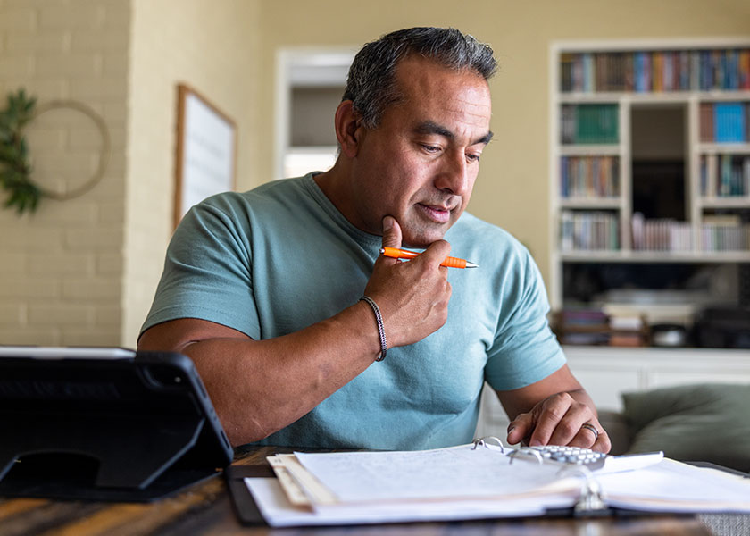 Man sitting at desk, looking through documents